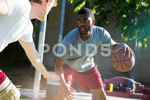 Two Men Playing Basketball On Outdoor Court