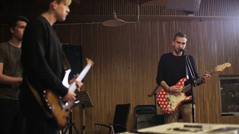 Two Men Playing Electric Guitars and a Vocalist Singing Stock Footage 72222216