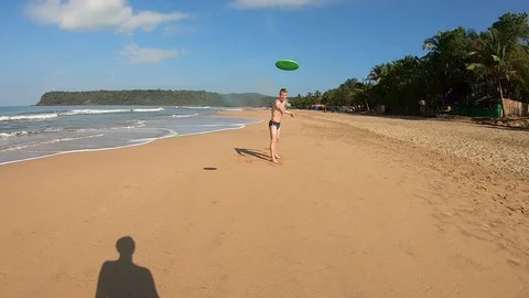 Two men playing frisbies on a beach on a sunny day Vídeos de archivo 128636537