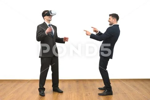 The two men playing game with a virtual reality glasses on the white backgrou Stock Photos