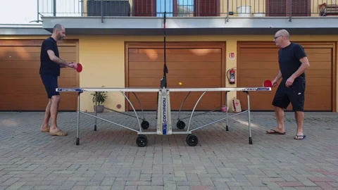 Two men playing ping-pong in backyard of house Stock Footage 280893245