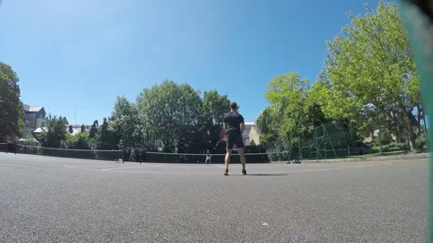 Two men playing tennis outside on a sunny day Stock Footage 79507612