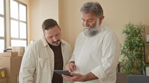 Two men point finger to tablet while checking stacked packages and discussi.. Stock Footage 339215097