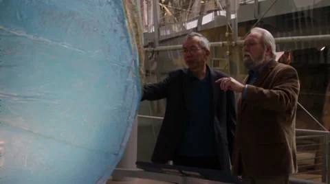 Two men points together to the globe and share information Stock Footage 36159440