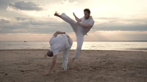 Two men practicing capoeira on beach Video stock 90135635