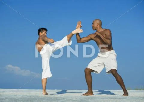 Two Men Practicing Martial Arts On Beach