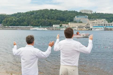 Two men praying. Two men in white clothes pray on the river bank Stock Photos