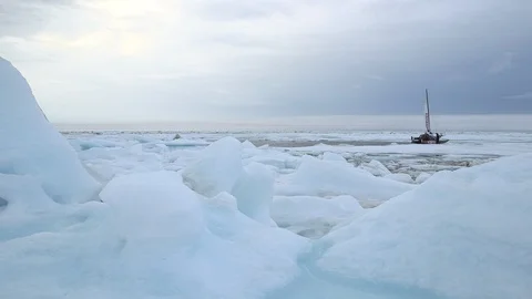 Two men preparing a catamaran on the ice floe, Arctic Ocean Video stock 104924459