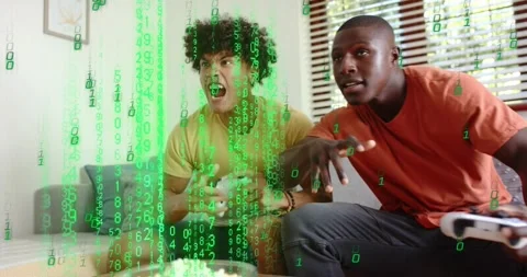 Two men pressing wireless controllers as green code streaming from screen fading Stock Footage 316606635