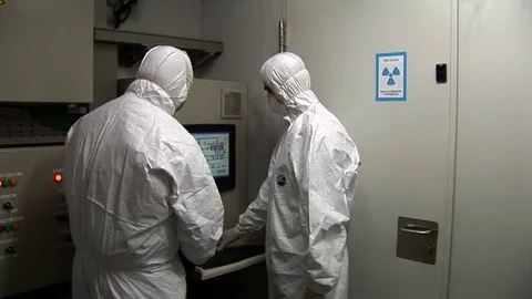 Two men in protective suit look at computer Stock Footage 73288461