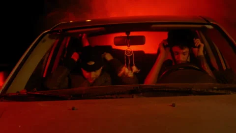 Two men pulling ski masks over their faces and getting out of a car Stock Footage 275175973