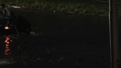 Two Men Push Car Through Flooded Street At Night. Heavy Rain Causes Dangerous Stock Footage 320603678