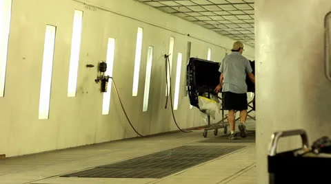 Two men push a truck bed into vehicle paint booth Stock-Footage 25879011