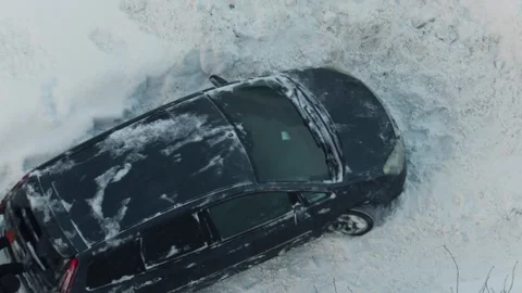 Two men pushing black car stuck in deep snow drift on cold winter day, vehicle Stock Footage 344846857