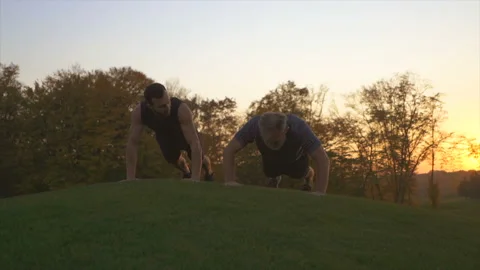 The two men pushing up in the park on the sunset background. slow motion Vídeo Stock 97724759