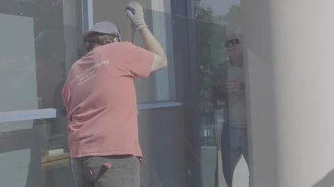 Two Men Putting a Large Blue Glass Window in Place - RAW Stock Footage 209289605