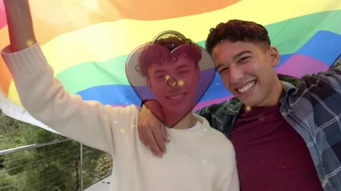 Two men raising pride flag and leaning to camera showing heart overlay marking Stock Footage 340674844