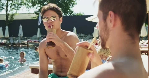 Two men relaxing near pool. Travelling and having holiday in the luxury hotel Stock Footage 158215904