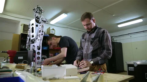 Two men repair the robot in the workshop Stock Footage 62022555