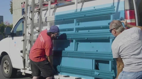 Two Men Replacing a Large Blue Glass Window Stock Footage 209289598