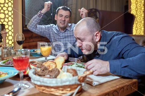 Two men in a restaurant arguing during lunch Stock Photos