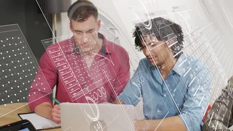 Two men reviewing tech data on laptop, one noting green pen, other typing Stock Footage 331270207