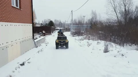 Two men ride ATV through the village Stock Footage 160285490