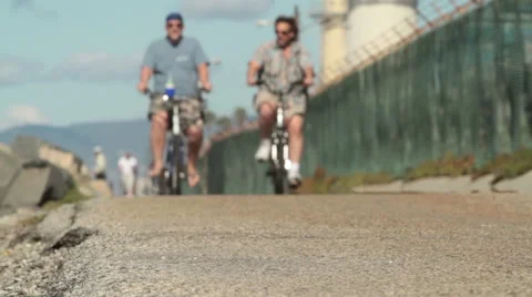 Two men ride bikes at the beach Stock Footage 46808269