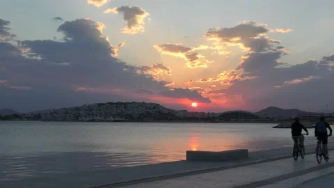 Two men ride bikes during sunset in Athens Greece 動画素材 139867463