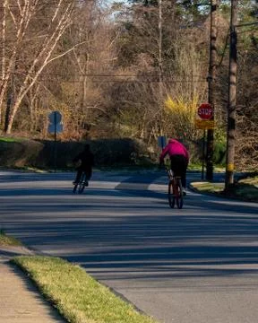 Two Men Riding Bicycles Down the Road Stock Photos