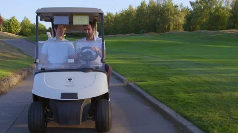 Two men riding in a golf cart Stock Footage 61044831