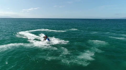 Two men riding a Jet ski with paintball Stock Footage 123985823