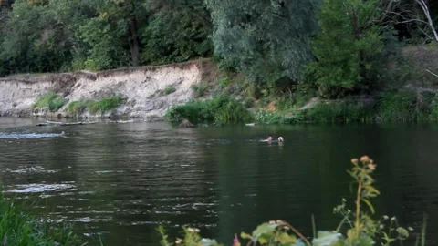 Two men in a river catch a ball Stock Footage 100980234