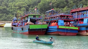Two Men Row A Boat In A Harbor With Old Wooden Ships Stock Footage 86098644