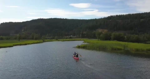 Two men row a canoe through shallow marshland in Lake Coeur d'Alene in northern  Stock Footage 284168855