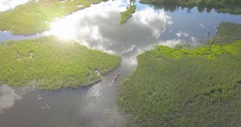 Two men row a canoe through shallow marshland in Lake Coeur d'Alene in northern  Stock Footage 284168874