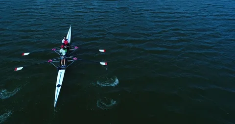 Two men row in kayak by wavy water surface at sunny day. Aerial shot of rowers Stock Footage 87946162