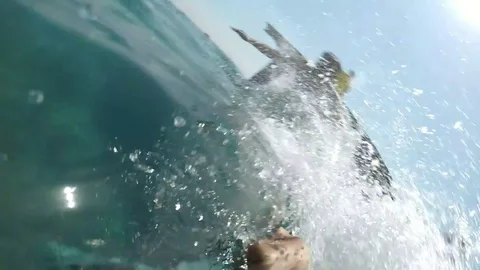 Two men run and jump feet first in sea waters while making selfie in slo-mo Stock-Footage 83733304