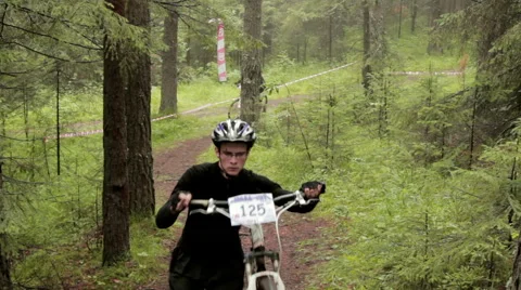 Two men run to the hill with mountain bike at Cross Country championship Stock Footage 52998038