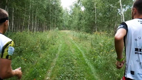 Two men runners run with camera behind Stock Footage 93846377