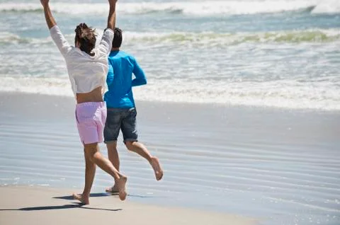Two men running on the beach Stock Photos