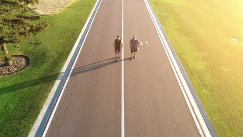 The two men running on the beautiful park road Stock-Footage 97667550