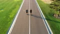 The two men running on the beautiful park road 4k or 4k+ Resolution