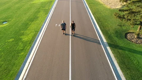 The two men running on the beautiful park road Vídeos de archivo 97667586