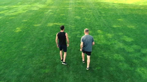 The two men running on the grass in a park Vídeos de archivo 97665721