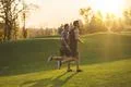 The two men running on the grass in the park on the sunrise background Photo