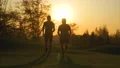 The two men running in the park on the beautiful sunrise background. slow motion 4k or 4k+ Resolution