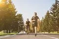 The two men running on the road in the park on the sunny background Photo