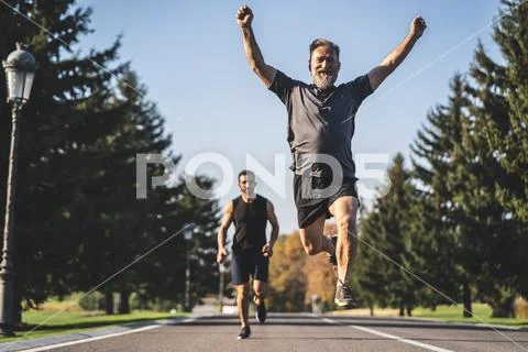 The two men running on the road in the park Stock Photos