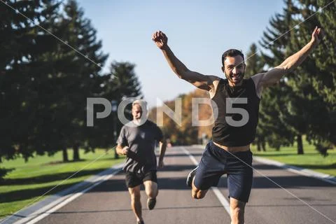 The two men running on the road in the park Stock Photos